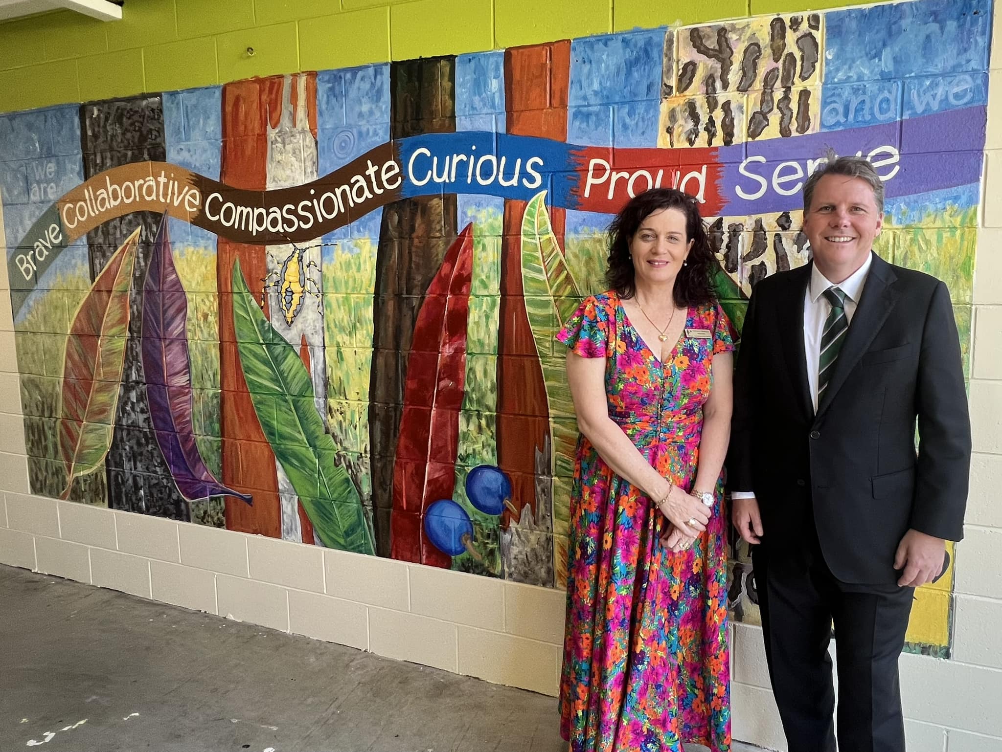 Local member Christian Rowan stands with Pullenvale State School Principal Natala Crowley in front of the Year 6 legacy mural
